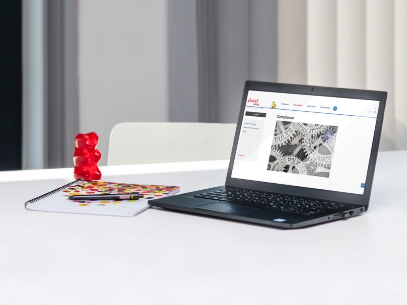 Laptop with a large red Goldbear on a table in an office