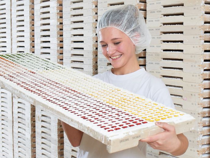 Mitarbeiterin begutachtet fertig gegossene Fruchtgummi-Figuren