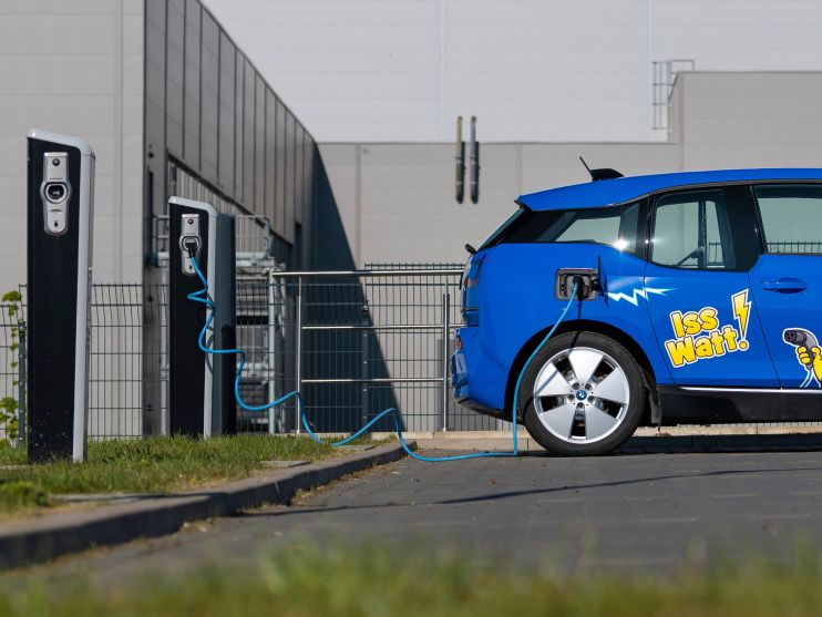 Blue electric car with HARIBO branding at charging station